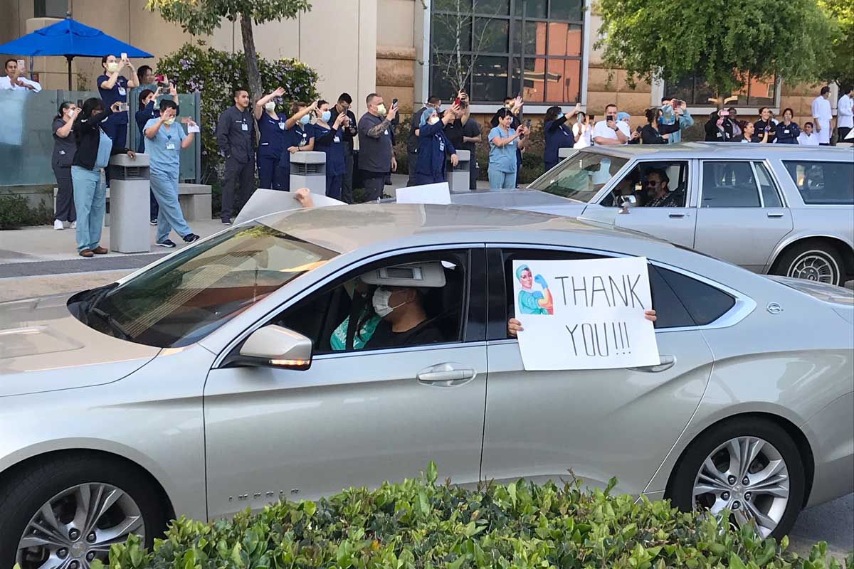 Car passenger holds thank you sign at UCI Medical Center